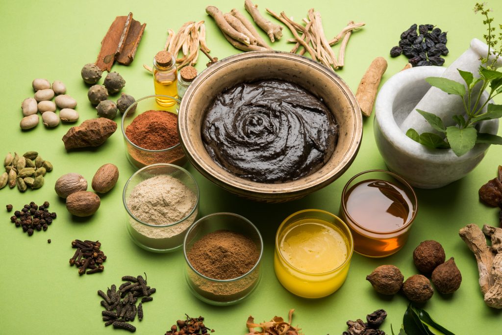 an assortment of spices and herbs on a green background